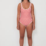 Woman wearing a red and white checkered swimsuit on a white background