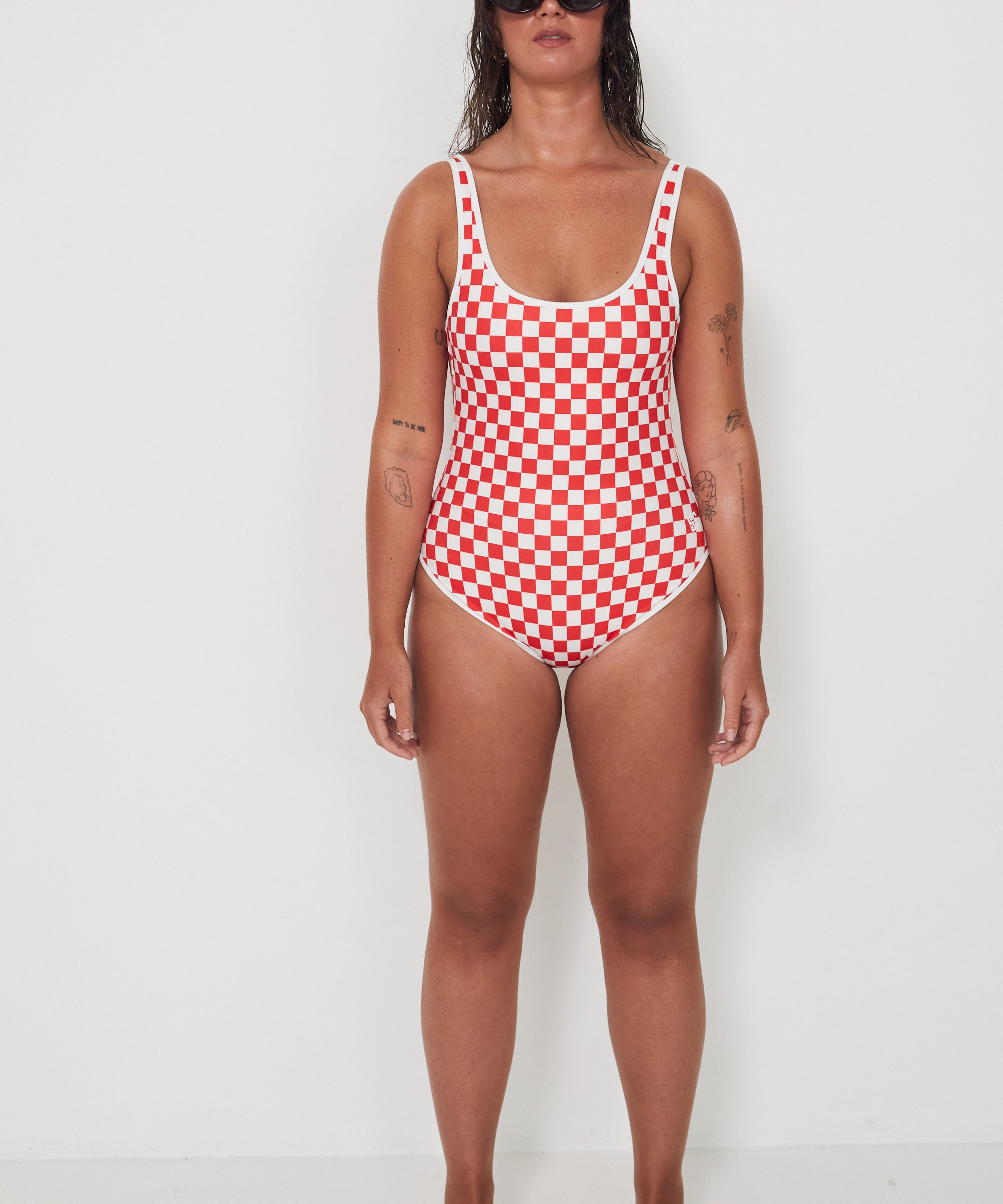 Woman wearing a red and white checkered swimsuit on a white background