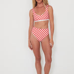 Woman wearing a red and white checkered bikini set on a white background