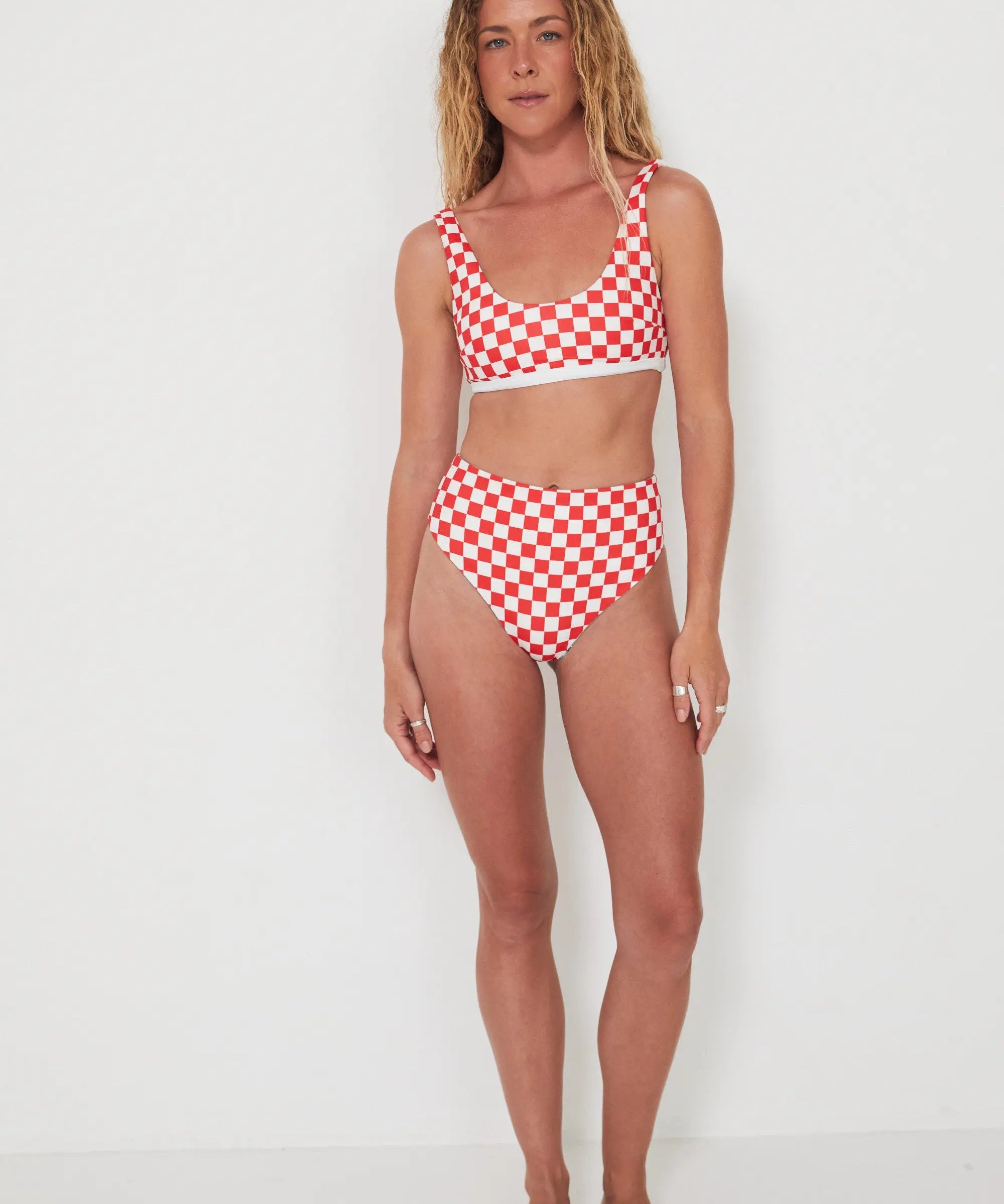 Woman wearing a red and white checkered bikini set on a white background