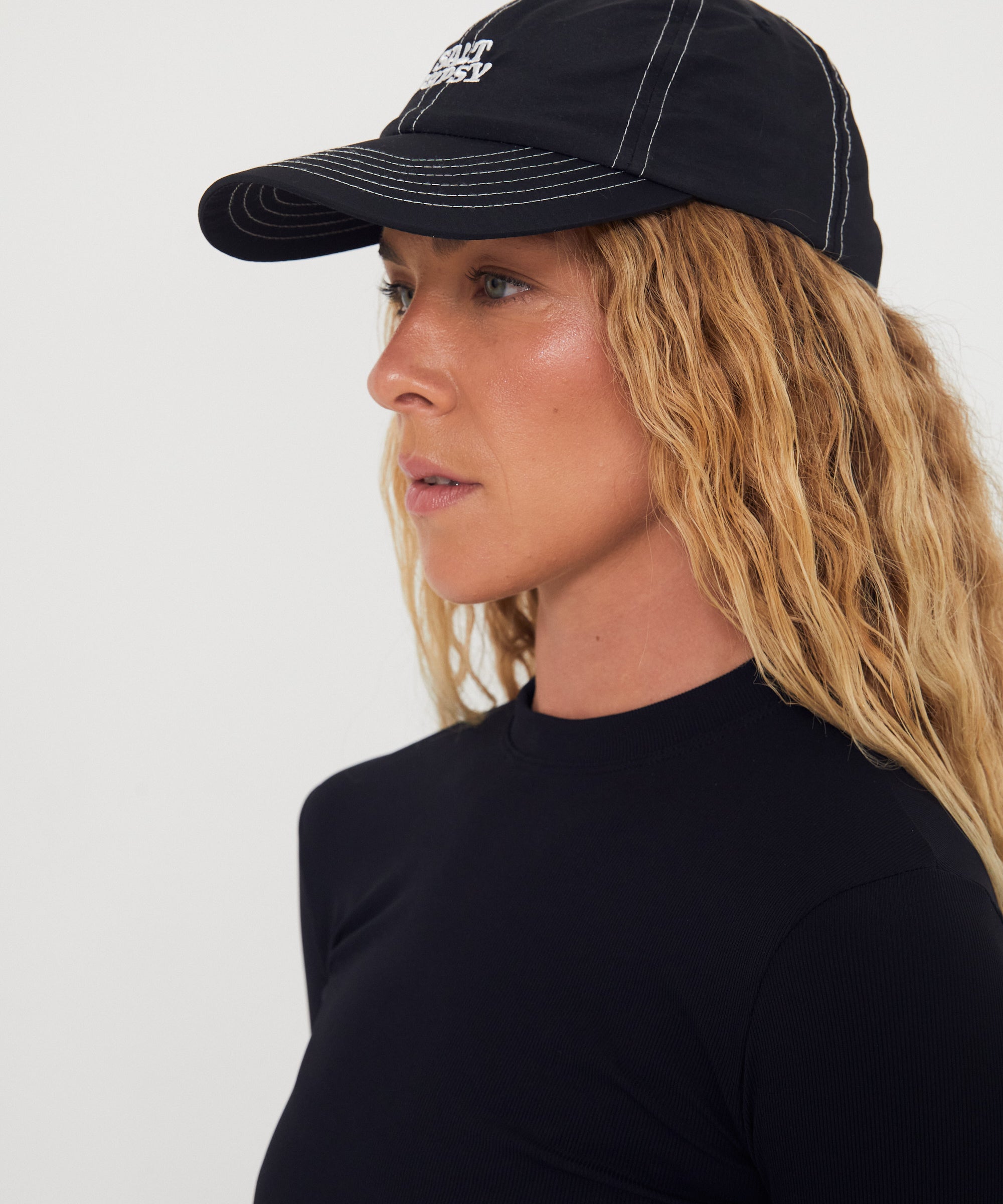 Woman wearing a black nylon cap with a logo on a white background