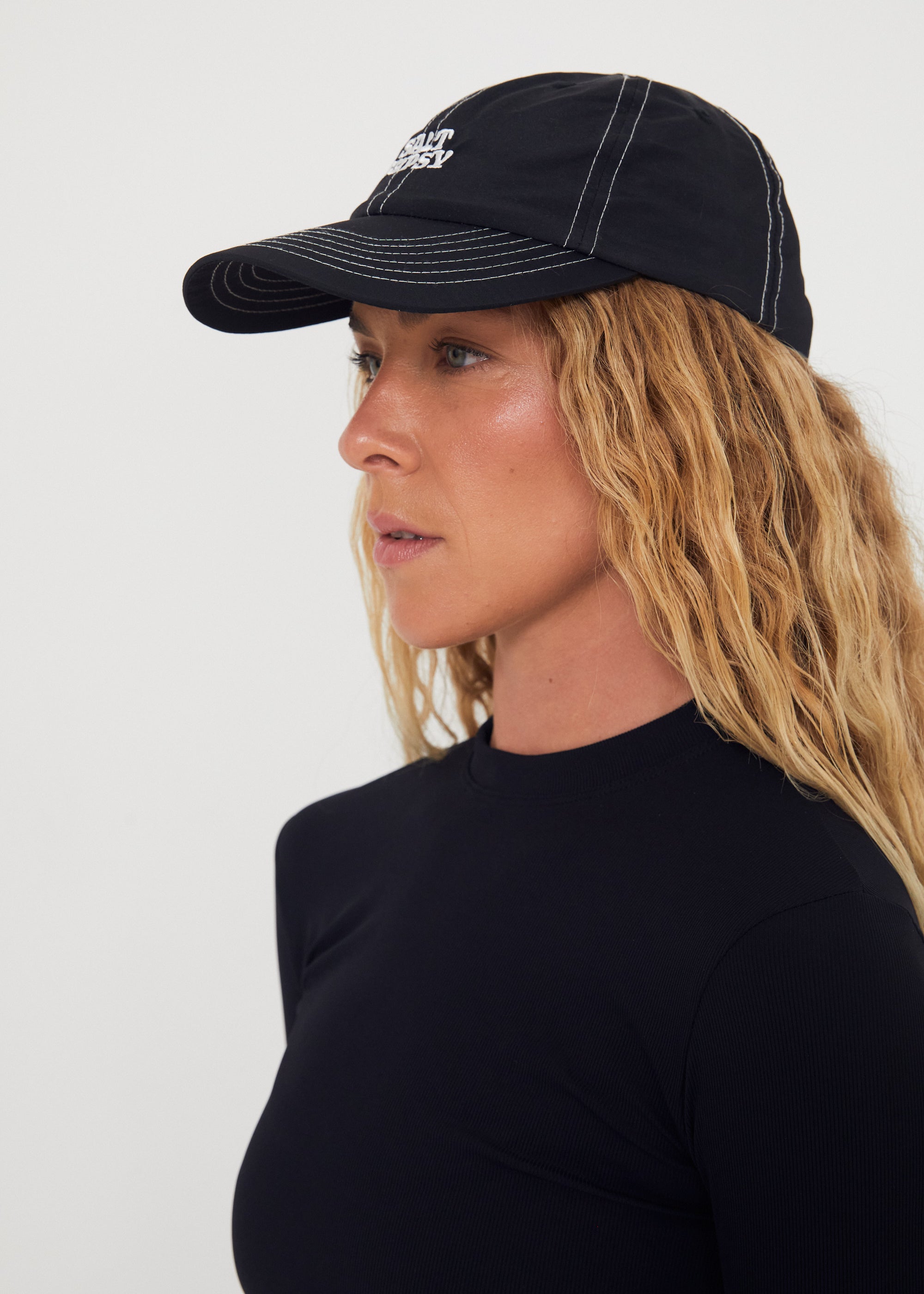 Woman wearing a black nylon cap with a logo on a white background