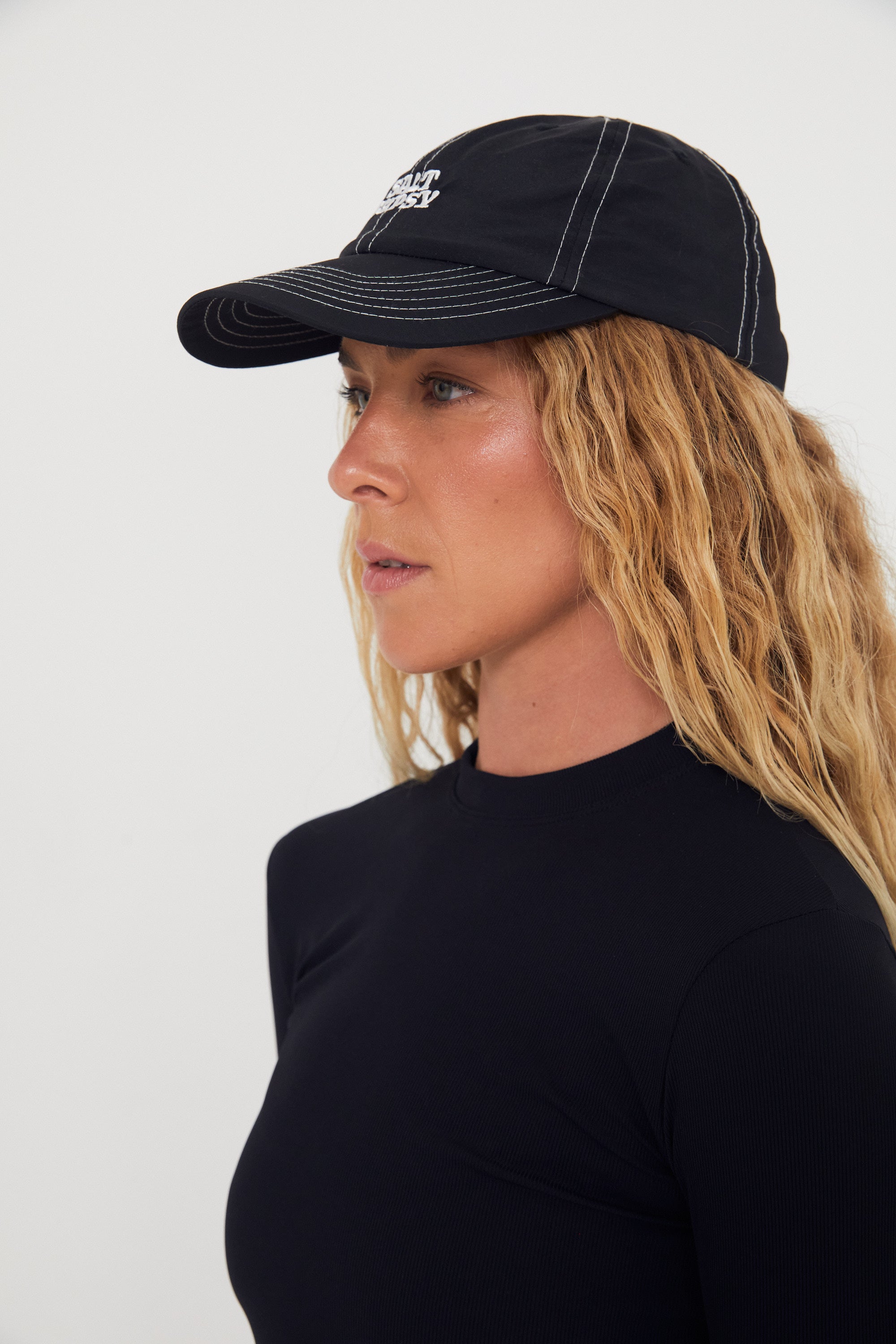 Woman wearing a black nylon cap with a logo on a white background