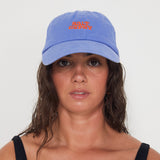 Woman wearing a blue dad cap with a red 'Salt Gypsy' logo on a white background